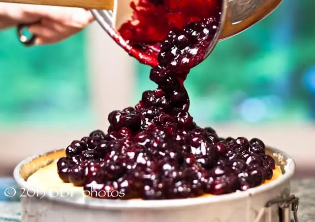 Pouring the topping over the cheesecake