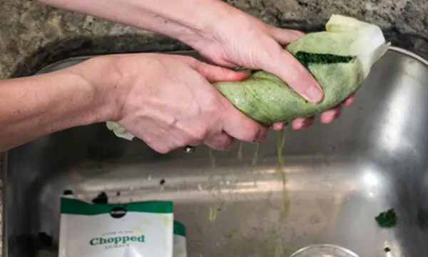 Squeezing water out of frozen spinach.