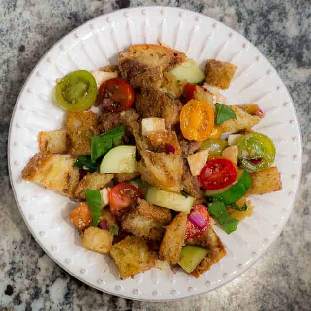 Panzanella is SCRUMPTIOUS! It's a traditional Italian bread salad recipe, and the best use of fresh summer tomatoes, fresh mozzarella, basil, and a balsamic vinaigrette I know! 