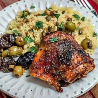 Chicken Marbella, a classic dish, is chicken roasted with garlic, olives, capers, and prunes. It's the perfect meal for a large dinner party. #dinnerparty #chicken #chickenrecipe