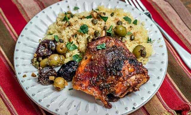 Chicken Marbella, a classic dish, is chicken roasted with garlic, olives, capers, and prunes. It's the perfect meal for a large dinner party. #dinnerparty #chicken #chickenrecipe
