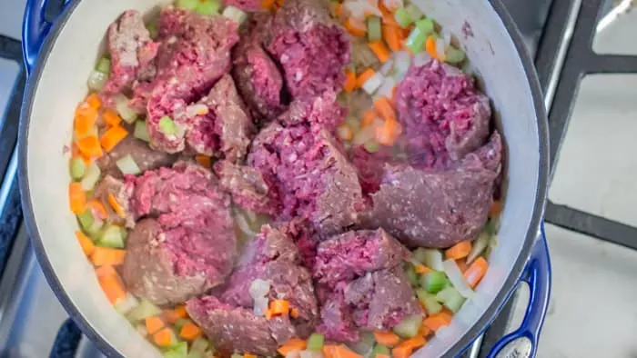 Adding the meat to the pot.