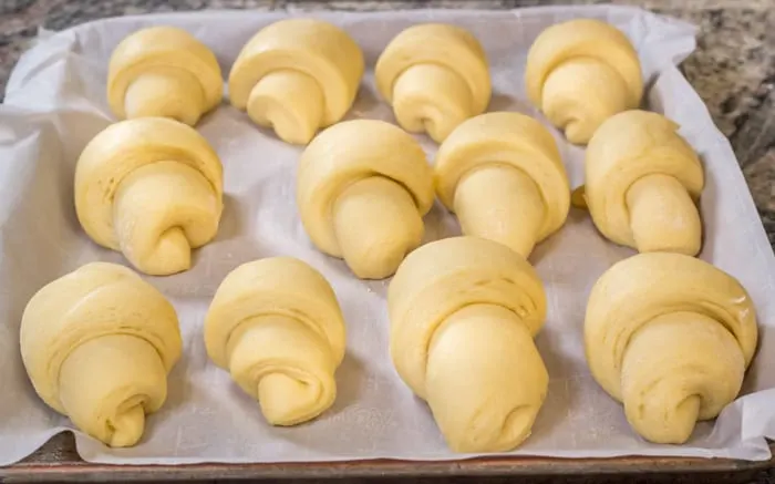 After the rolls have risen for an hour, they're ready to brushed with an egg white wash, sprinkled with sesame seeds, and baked.