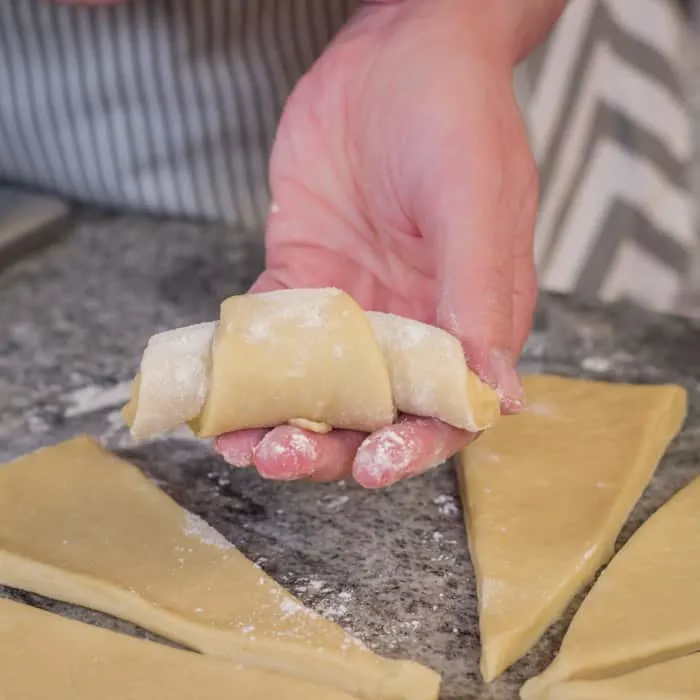 Starting with the widest end, roll up each wedge into a crescent. Make sure the tip is tucked under at the bottom of the baking sheet.