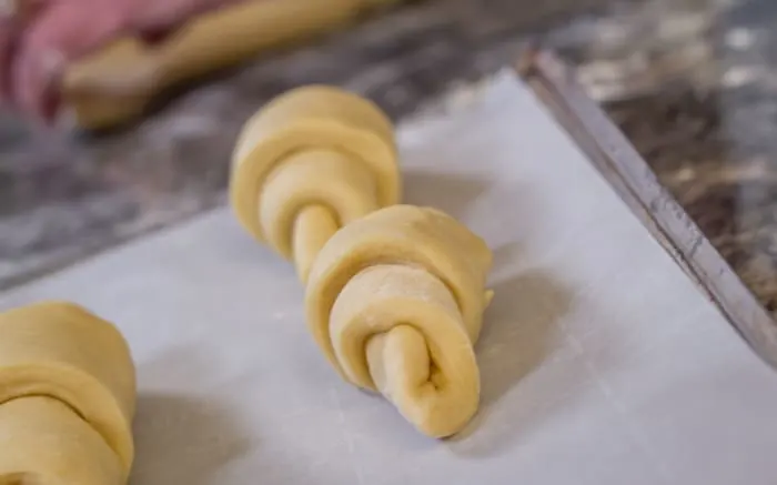 Place the rolled crescents on a baking sheet covered with parchment paper.