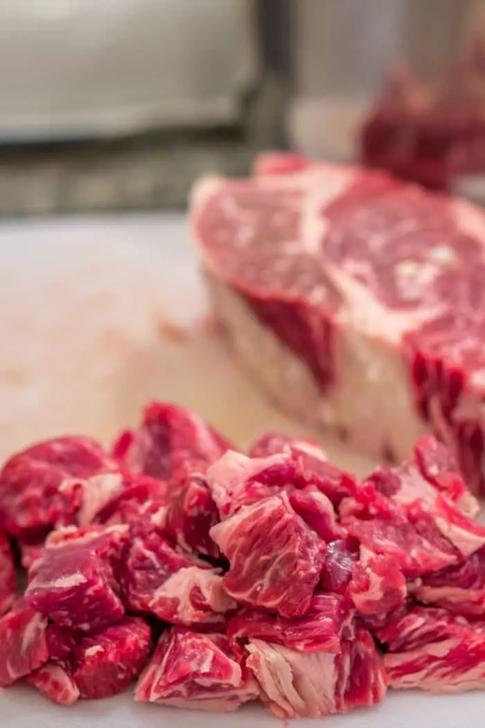 Chuck roast, being trimmed of fat, and cubed