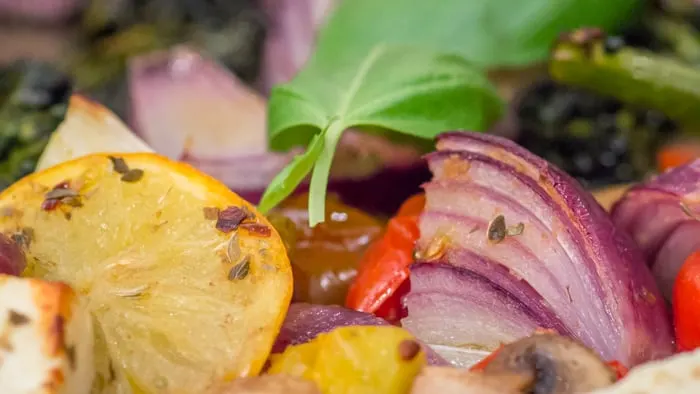 A close up of the roasted veggies, out of the oven, having been garnished with the basil.