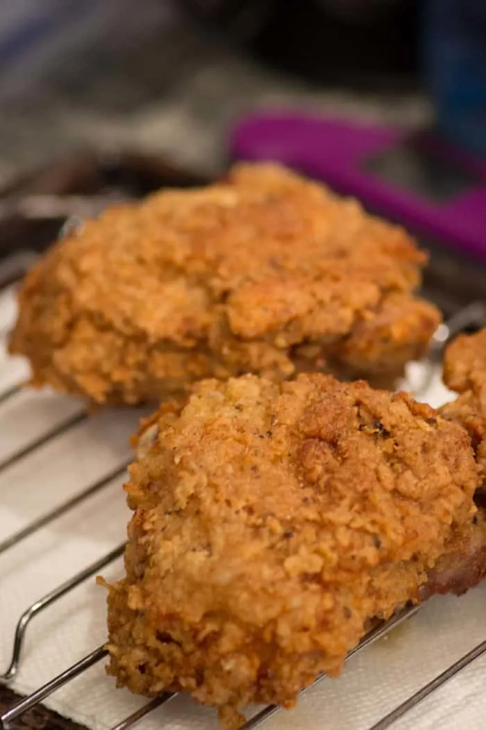 Draining the chicken on a rack over paper towels.