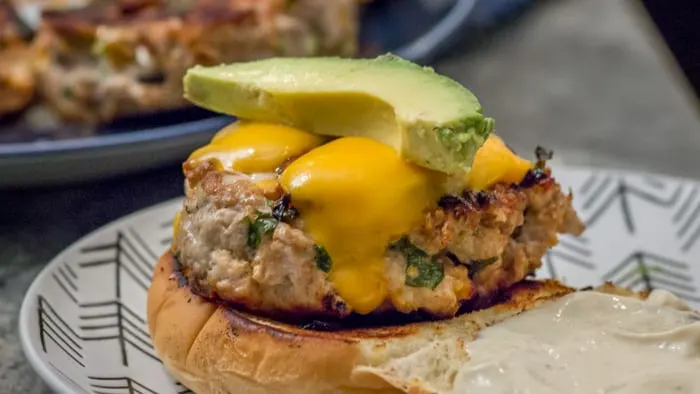Building the burger with a slice of creamy avocado. Don't forget to add lettuce!