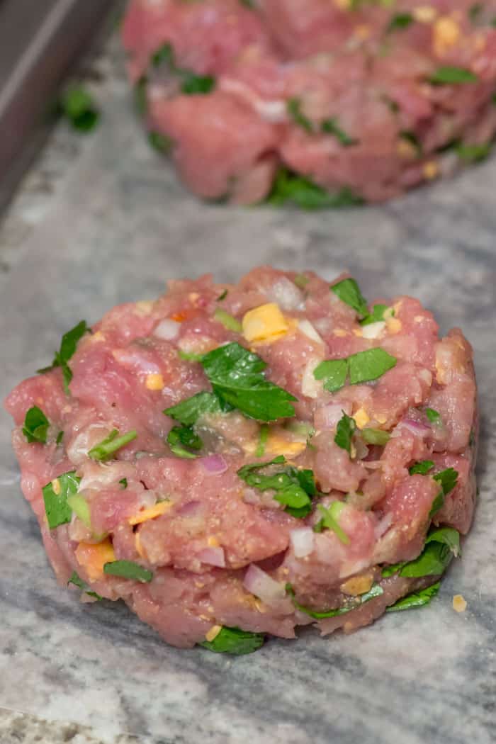 The meat, cheese, garlic, shallots, parsley and spices get formed into patties.