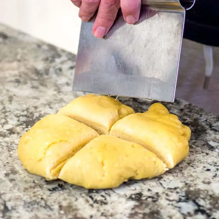 I used a bench scraper to divide the disc of pasta dough into 4 approximately equal sections. You'll want to cover the pieces you aren't working with with plastic, or a damp towel.