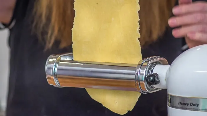 After rolling one fourth of your dough into a rectangular shape with a rolling pin, you feed the dough through the widest setting of the roller attachment. 