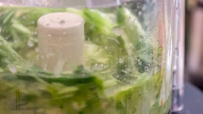 The whirring of the cilantro, jalapeño, garlic and olive oil in the food processor