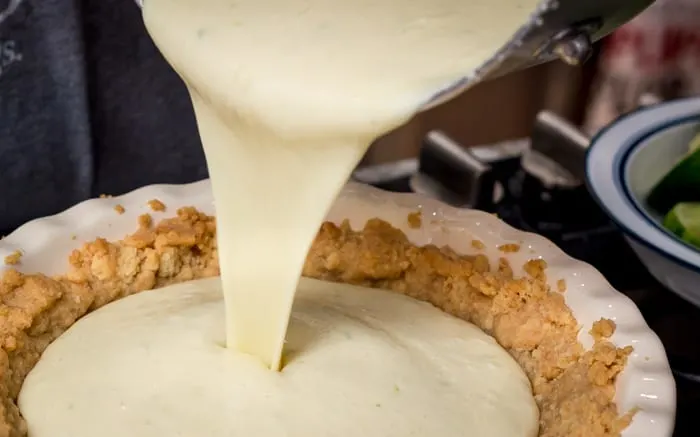 Pouring the custard into the baked pie shell.