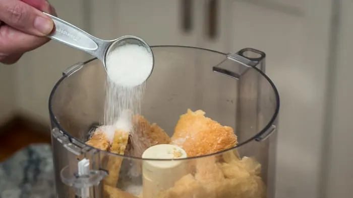 Sprinkling a bit of sugar onto the shortbread in the food processor.