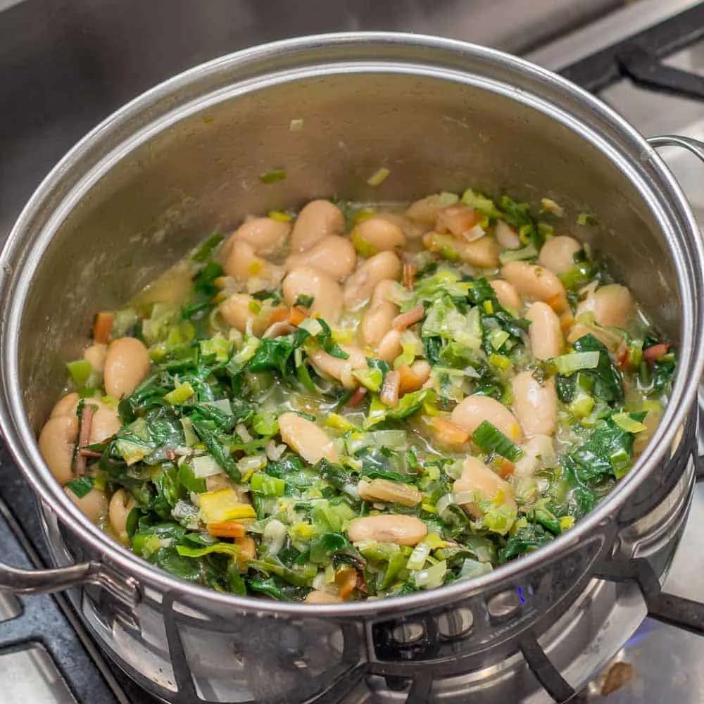 Mixing all the ingredients together for Parmesan White Bean Soup with Swiss Chard and Leeks