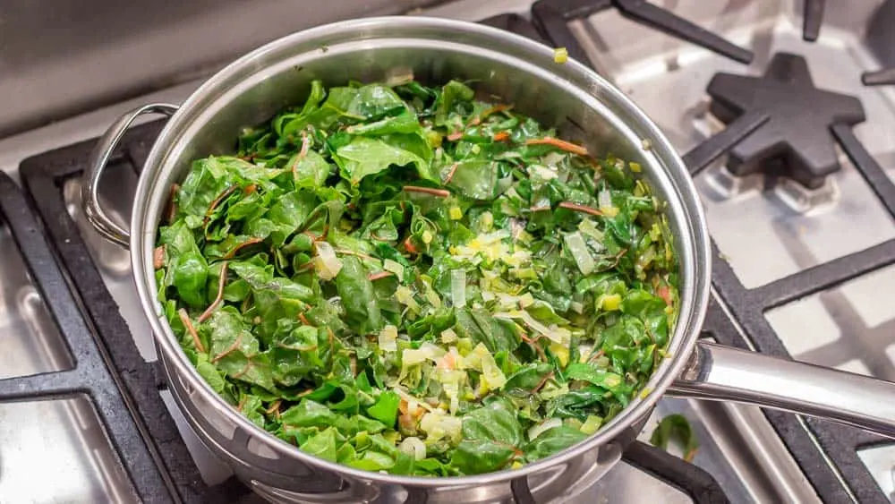 Sautéing the leeks, the chard stems, and finally the leaves of the chard.