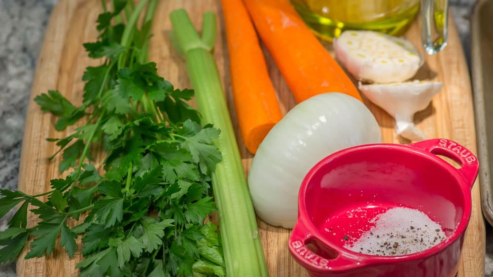 Parsley, celery, carrots, onion, and a whole head of garlic, plus sea salt and freshly ground black pepper.