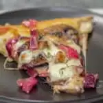 A slice of Mushroom Havarti Caramelized Onion Pizza