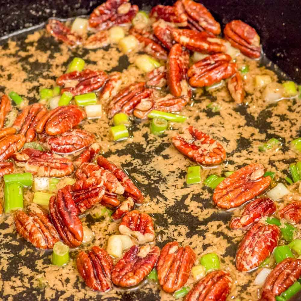 Add green onions and pecans to the dressing in the skillet.