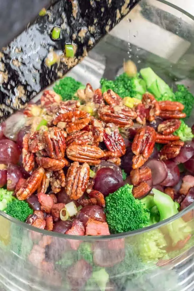 Scraping the warm vinaigrette from the skillet, onto the salad.