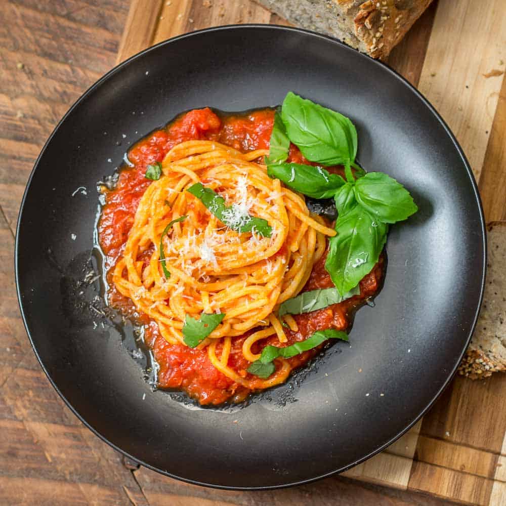 A plate of tonnarelli with marinara sauce.