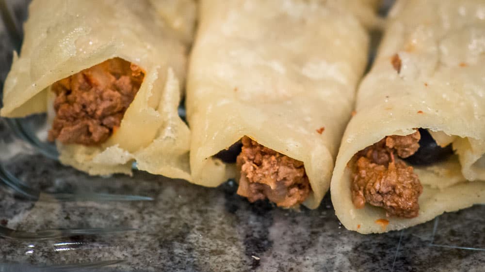 Stuffed and folded enchiladas in the pan.