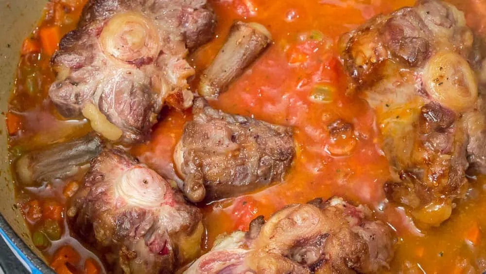 Adding in all the browned oxtail chunks, just before putting it into the oven. 