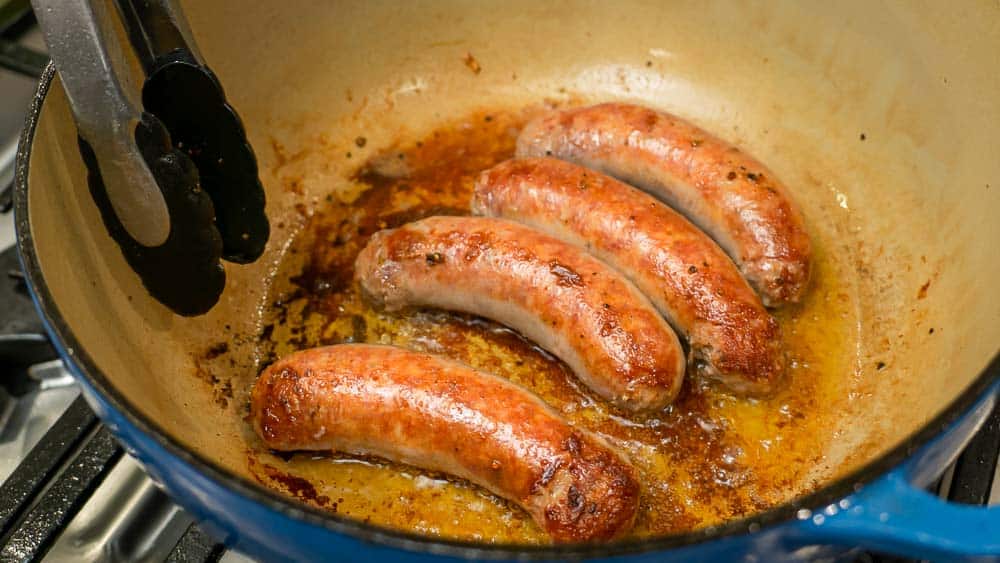 Browning the sausages in the chicken fat.