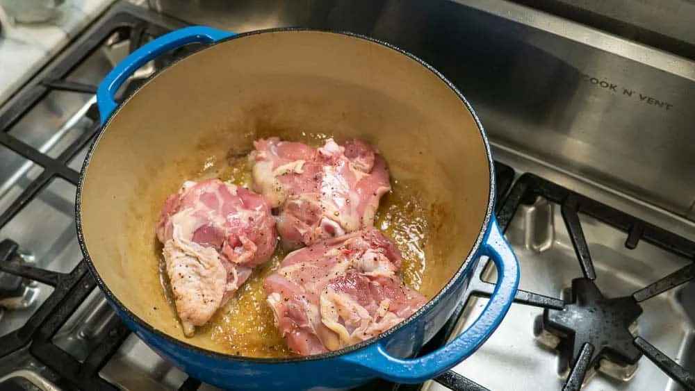 Browning the chicken skin side down first.