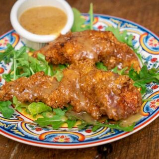 Wild Turkey Tenders with Honey Mustard Dipping Sauce on a bed of arugula.