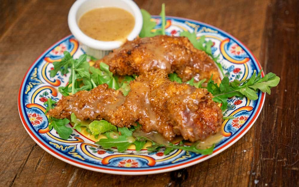 Wild Turkey Tenders with Honey Mustard Dipping Sauce on a bed of arugula.