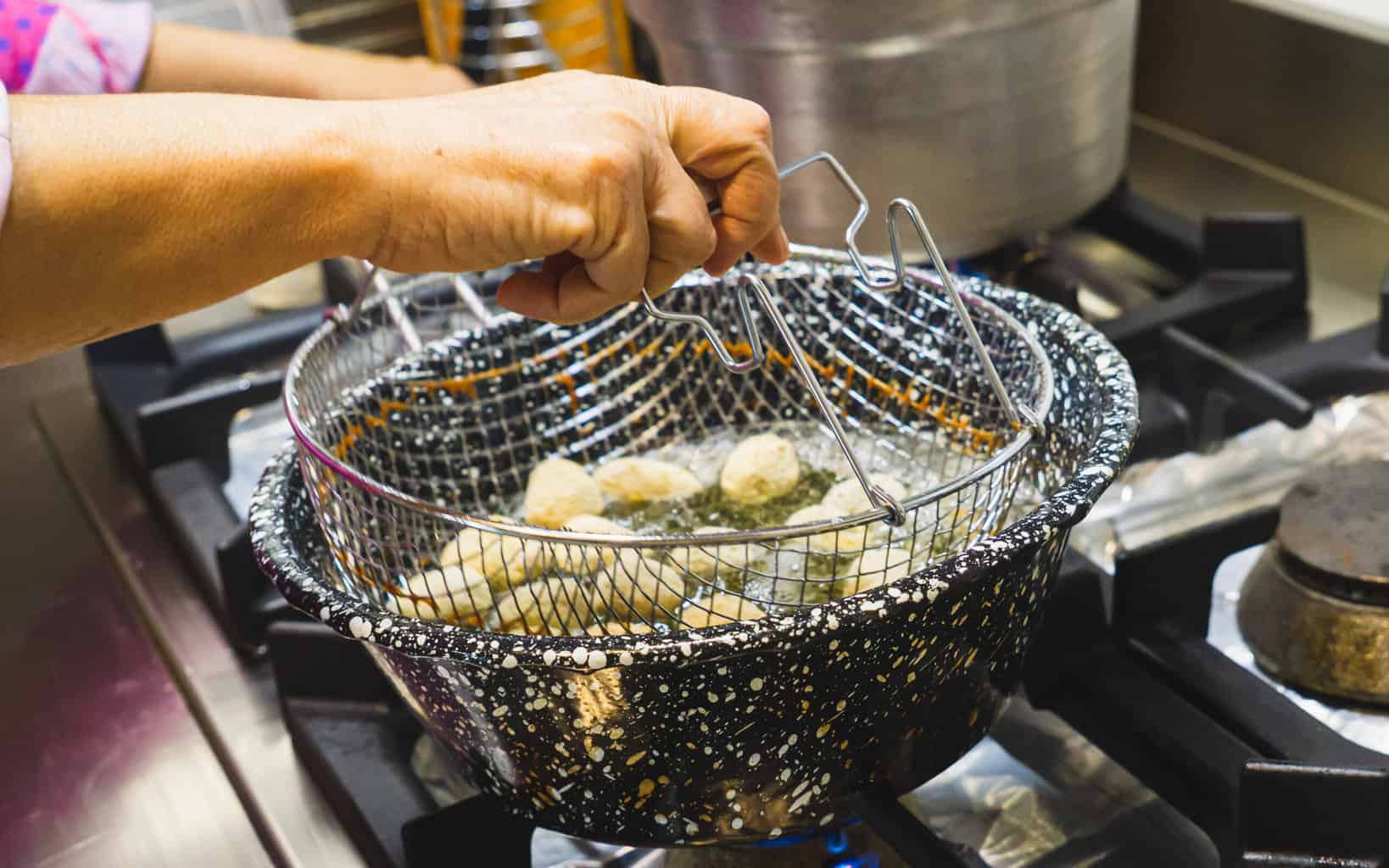 This is a picture of us deep frying the olives, after they have been breaded, in Simone's kitchen.