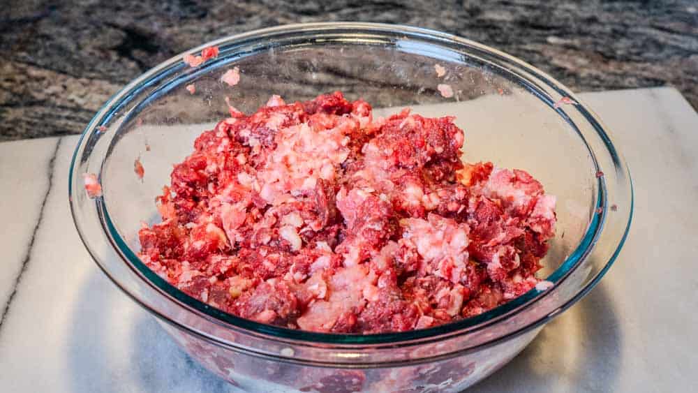 I mix the venison, ground turkey, and ground pork in a bowl with the egg. 
