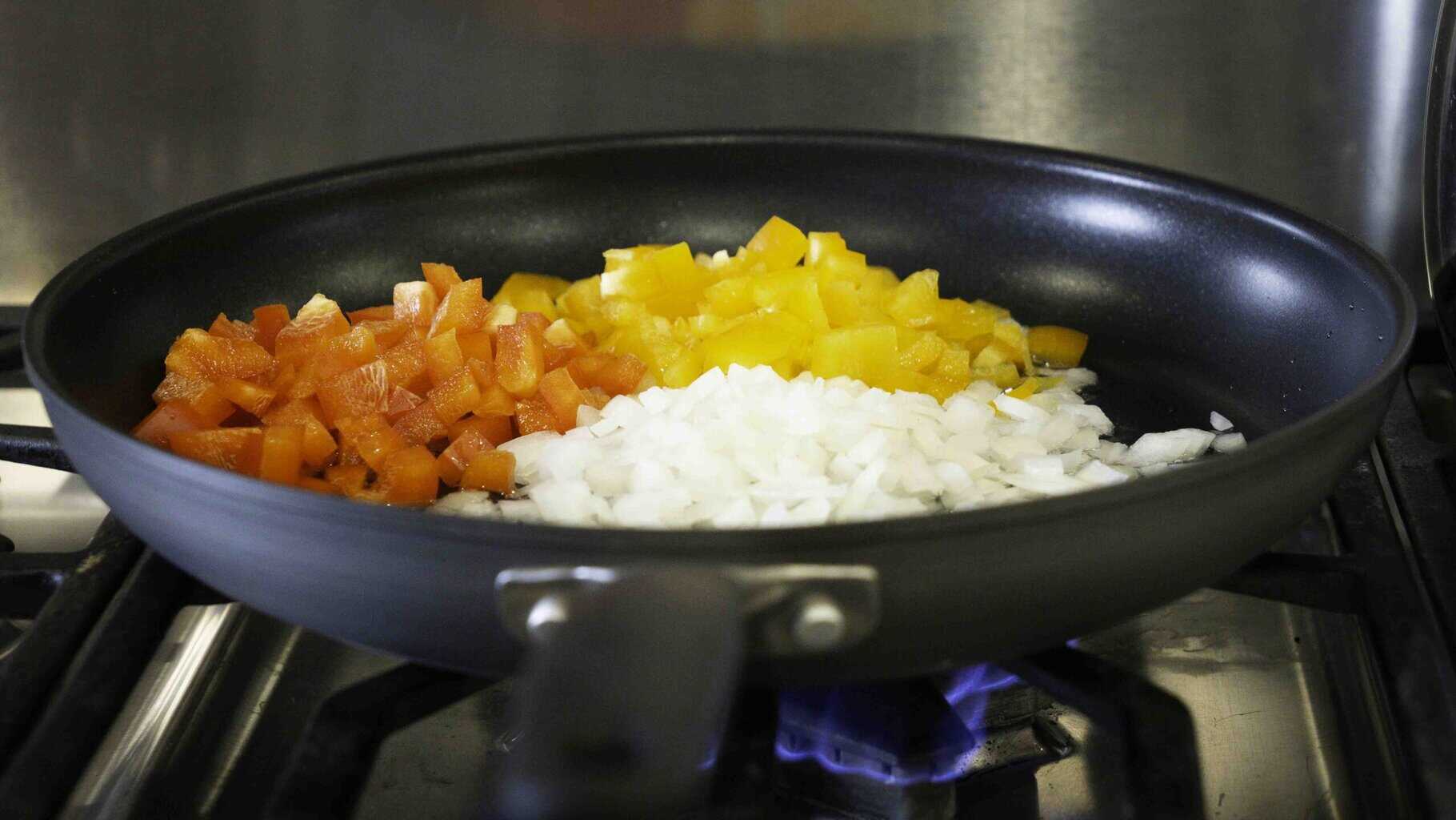 We start out by cooking our bright bell peppers and onions together.