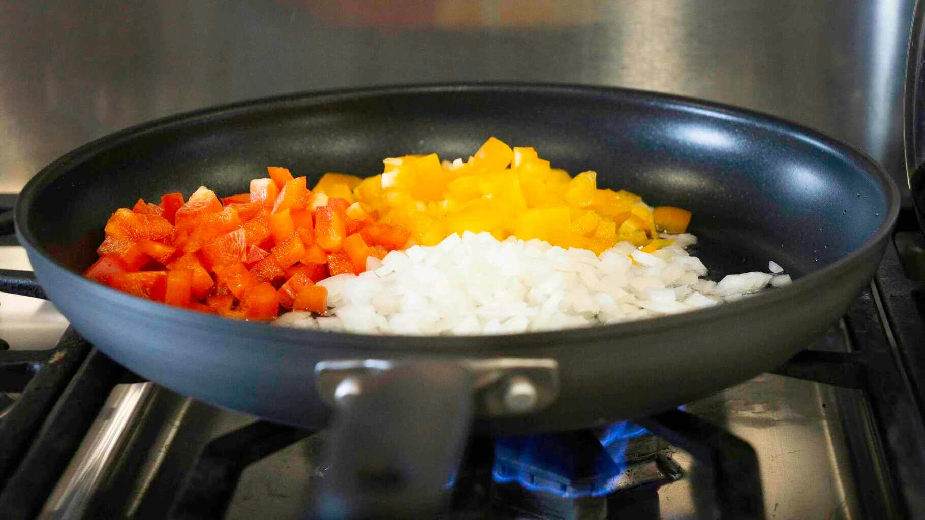 We start out by cooking our bright bell peppers and onions together.